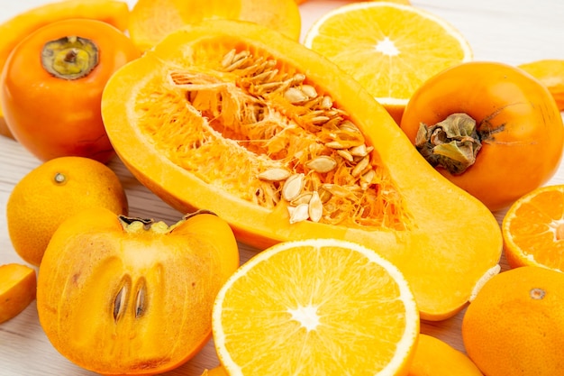 Vista inferior com fatias de abóbora, metade tangerinas e caquis laranja