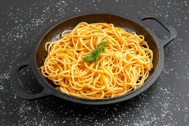 Vista inferior da frigideira de espaguete na mesa preta