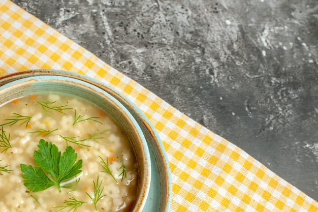 Foto grátis vista inferior da sopa estrela em uma tigela na toalha de mesa amarela no escuro