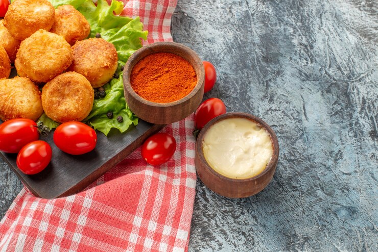 Foto grátis vista inferior de bolinhos de queijo frito com especiarias em pequenas tigelas na tábua