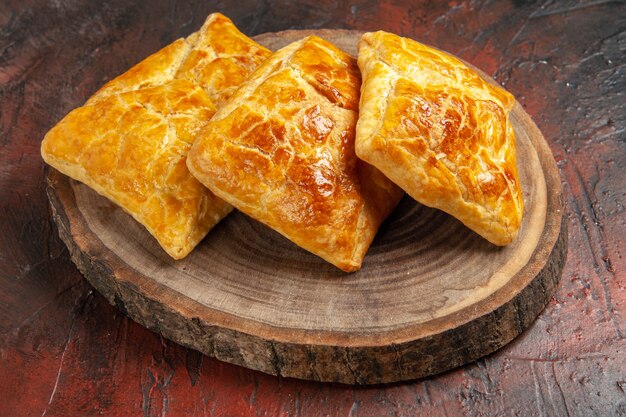 Vista inferior de penovani khachapuri em placa de madeira em mesa vermelha escura culinária georgiana