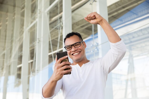 Vista inferior, de, sorrindo, homem jovem, acabamento, telefonema, exulting