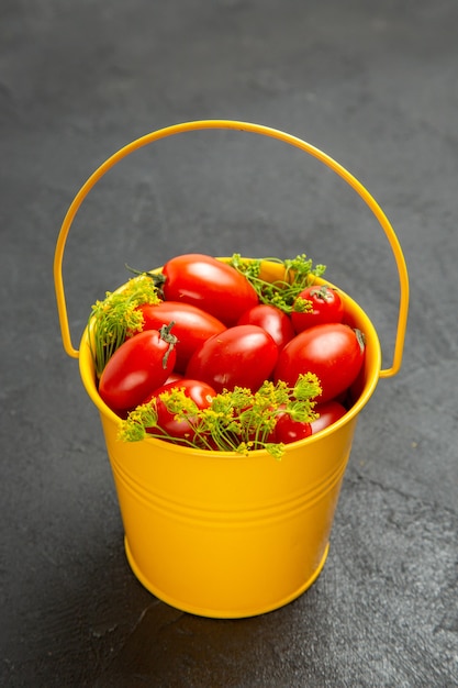 Foto grátis vista inferior do balde de tomates cereja e flores de endro em fundo escuro