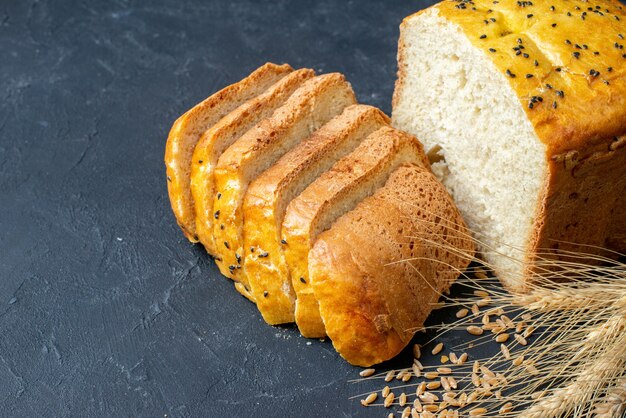 Vista inferior do pão fatias espigas e grãos de trigo no espaço livre da mesa escura
