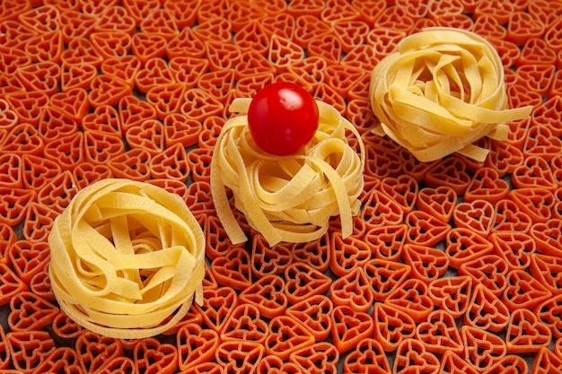 Vista inferior do tagliatelle em macarrão italiano com tomate cereja em forma de coração