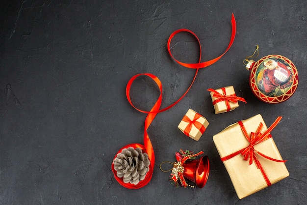 Vista inferior dos presentes de natal em fita de papel pardo, brinquedos para árvore de natal em jornal em bege