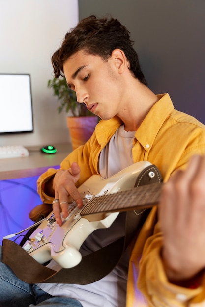 Foto grátis vista lateral adolescente tocando violão em casa