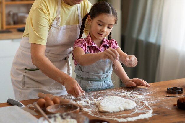 Vista lateral avó e menina cozinhando juntos