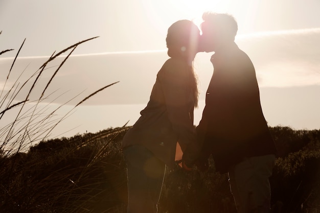 Foto grátis vista lateral casal beijando ao ar livre