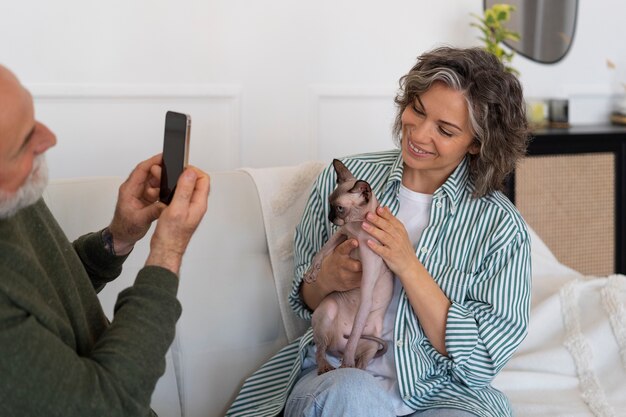 Foto grátis vista lateral casal sênior com gato em casa