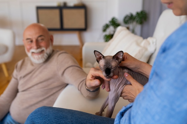 Foto grátis vista lateral casal sênior com gato em casa