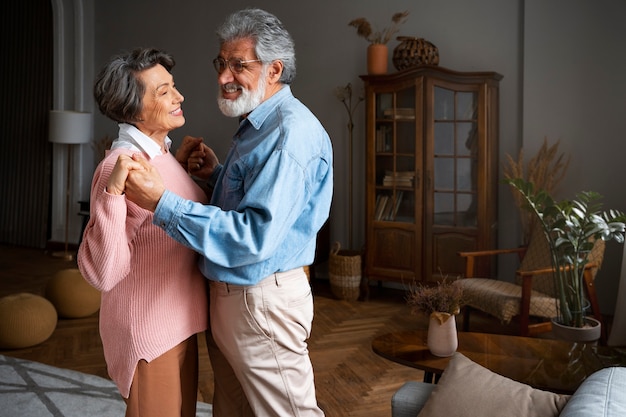 Foto grátis vista lateral casal sorridente dançando em casa