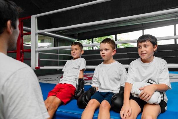 Vista lateral crianças aprendendo boxe