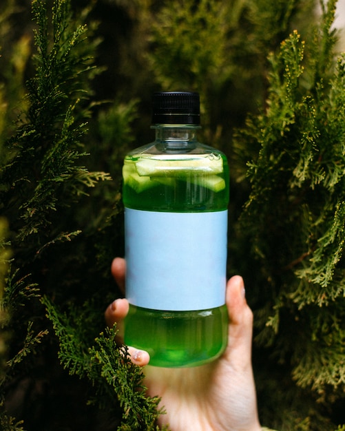 Vista lateral da bebida de desintoxicação de smoothie verde em garrafa verde
