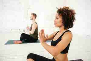 Foto grátis vista lateral da jovem mulher africana fazendo yoga