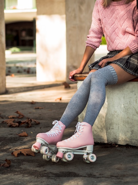 Foto grátis vista lateral da mulher de meias e saia com patins