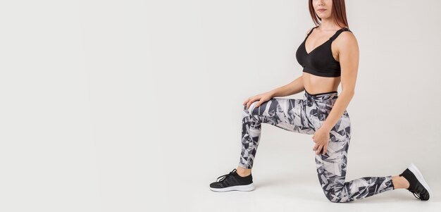 Vista lateral da mulher posando em athleisure com espaço de cópia