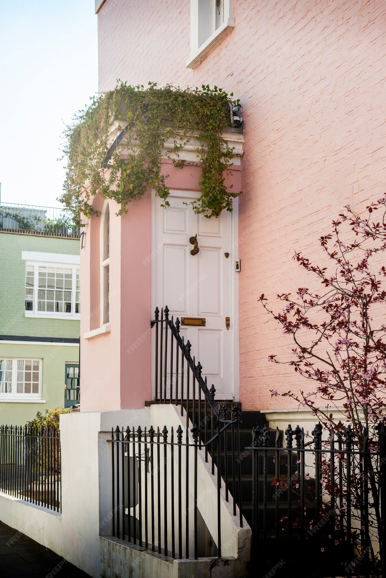 Uma casa rosa com um exterior rosa e uma porta rosa.