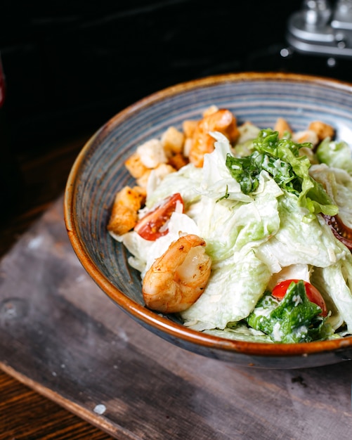 Foto grátis vista lateral da salada caesar de camarão com tomate cereja na tigela