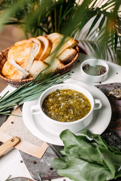 Vista lateral da sopa de beterraba verde russa tradicional com carne azeda e ovos em uma placa de madeira