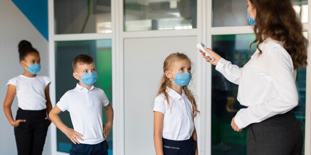 Vista lateral das crianças de volta à escola em época de pandemia