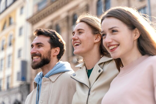 Vista lateral de amigos sorridentes ao ar livre na cidade