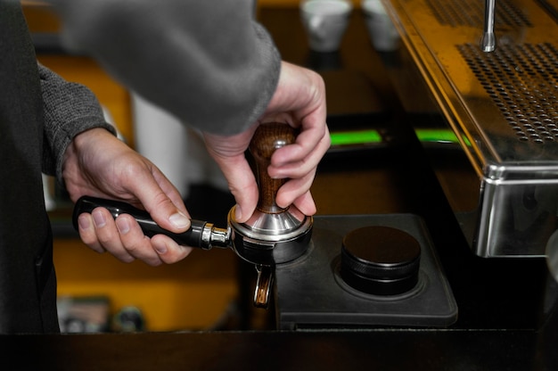 Vista lateral de barista masculino com máquina de café