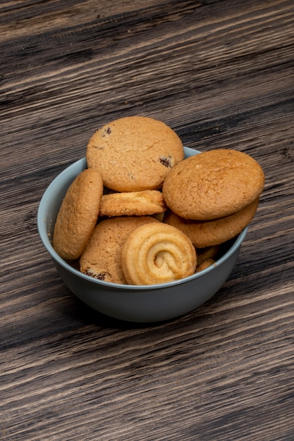 Foto grátis vista lateral de biscoitos de aveia em uma tigela no rústico