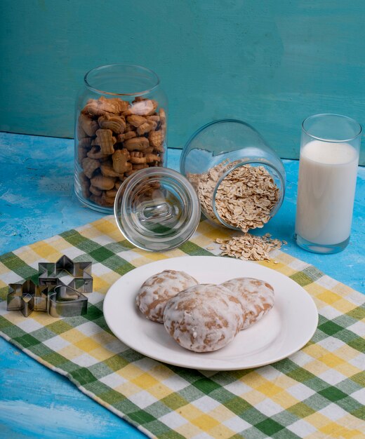 Vista lateral de biscoitos de gengibre em um prato branco na mesa da cozinha