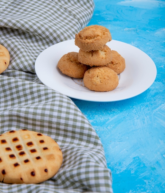 Vista lateral de biscoitos em um prato branco no azul