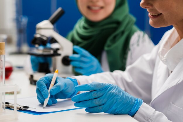 Vista lateral de cientistas femininos no trabalho no laboratório