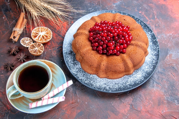 Foto grátis vista lateral de close-up de bolo com bolo de frutas vermelhas com groselha uma xícara de chá com doces e limão canela