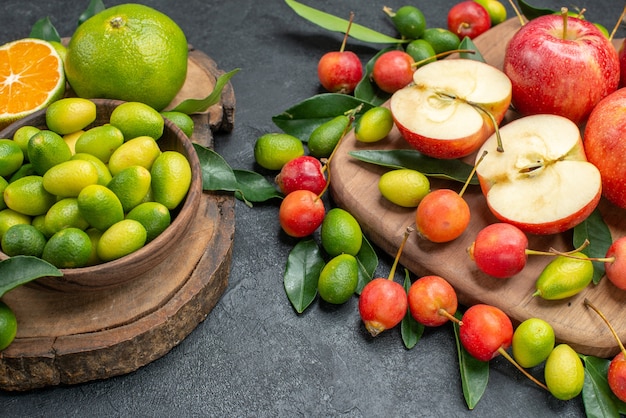 Vista lateral de close-up frutas cítricas em uma tigela, maçãs vermelhas, cerejas no quadro