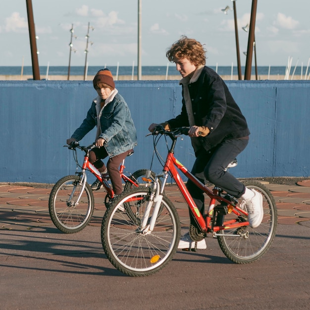 Vista lateral de crianças amigas ao ar livre em bicicletas