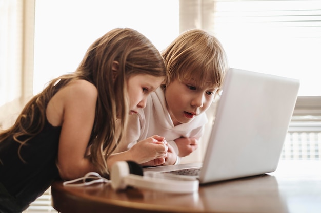 Vista lateral de crianças usando laptop juntas