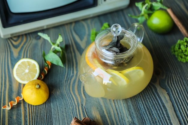 Vista lateral de gengibre chá limão hortelã água quente canela
