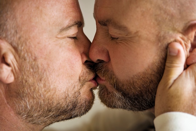 Vista lateral de homens queer se beijando