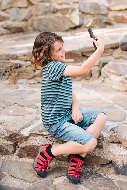 Vista lateral, de, menino, fazendo exame um selfie