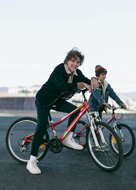 Vista lateral de meninos felizes ao ar livre na cidade com suas bicicletas