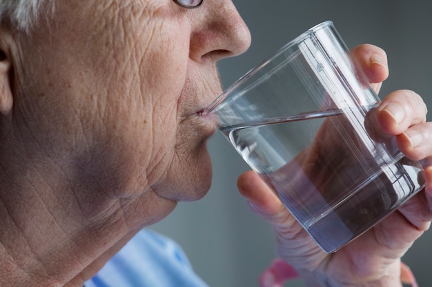 Vista lateral, de, mulher idosa, bebendo, água