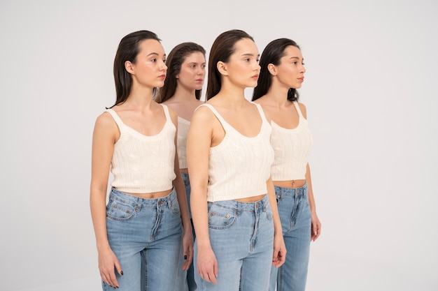 Vista lateral de mulheres em tops e jeans posando em retratos minimalistas