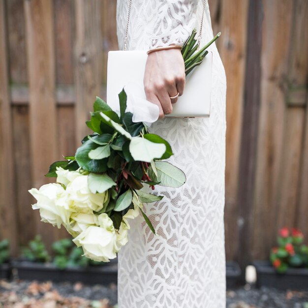 Vista lateral, de, noiva, segurando, rosas brancas, e, embreagem