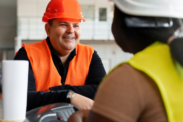 Vista lateral de pessoas de tamanho grande que trabalham na construção