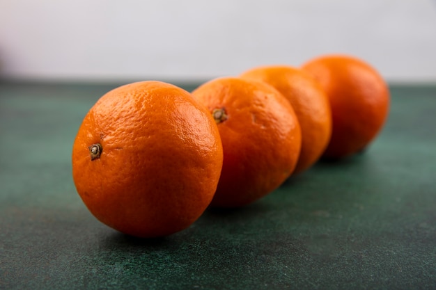 Vista lateral de tangerinas em um fundo verde