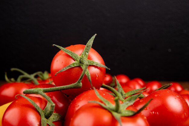 Vista lateral de tomates em fundo preto