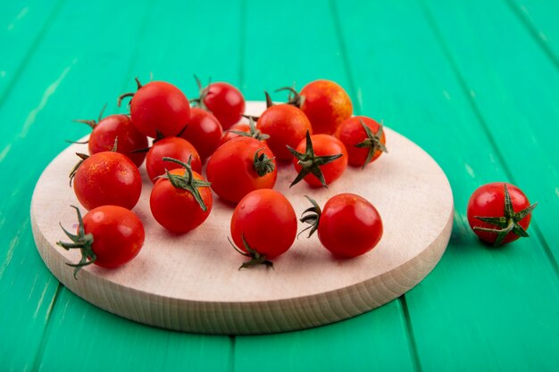 Vista lateral de tomates em uma tábua em verde