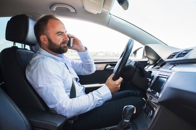 Vista lateral, de, um, assento homem, dentro, carro, falando, ligado, cellphone