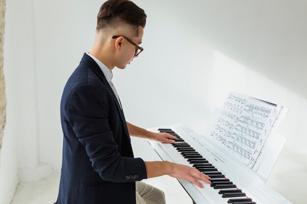 Vista lateral, de, um, bonito, homem jovem, piano jogando