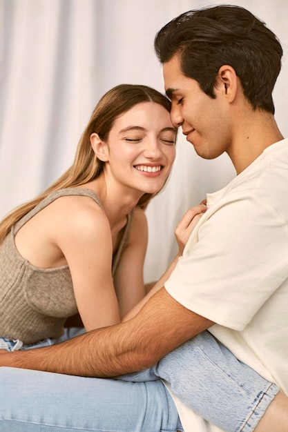 Vista lateral de um casal sorridente abraçado
