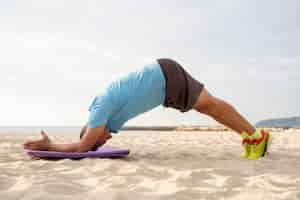 Foto grátis vista lateral de um homem mais velho fazendo exercícios na praia